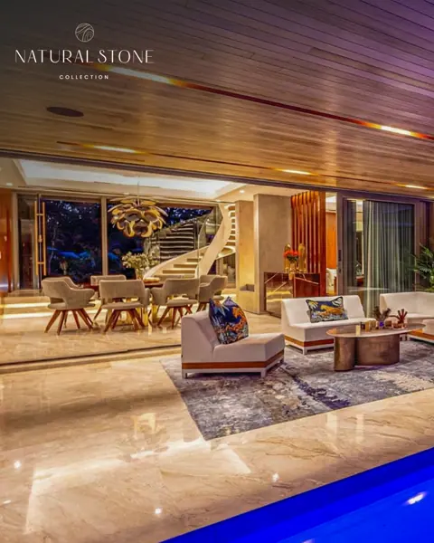 Warm beige natural stone is used for the floor throughout the room, alongside wide glazing and an open connection between spaces.