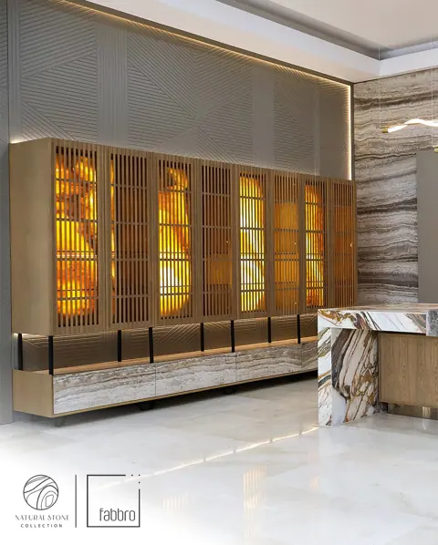 Grey veined stone is used for the breakfast counter, alongside warm metallic details and carefully placed lighting.
