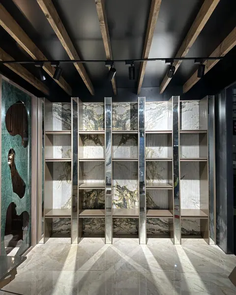 Grey veined stone is used for the entrance floor and architectural details, alongside wide glazing and an open connection between spaces.