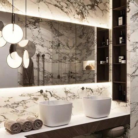 Stone with mirrored veining is used for the vanity and its surrounding surfaces, alongside pendant lights and simple cabinetry.