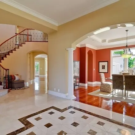 Contrasting natural stone colours is used for the entrance floor and architectural details, alongside contrasting borders and a carefully composed floor pattern.