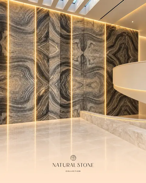 Mirrored bands of dark and light stone form a dramatic feature wall, with vertical lighting drawing attention to the symmetrical vein pattern.