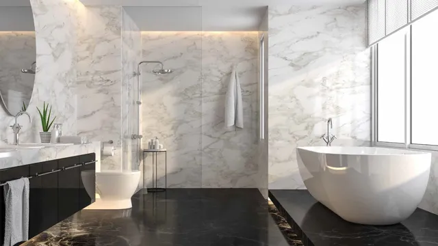 Pale veined walls, a freestanding bath and dark stone flooring create a crisp contrast in this contemporary bathroom.